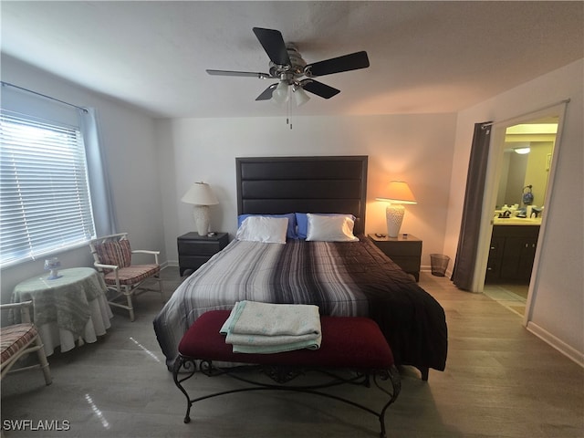 bedroom featuring light hardwood / wood-style flooring, ensuite bathroom, and ceiling fan