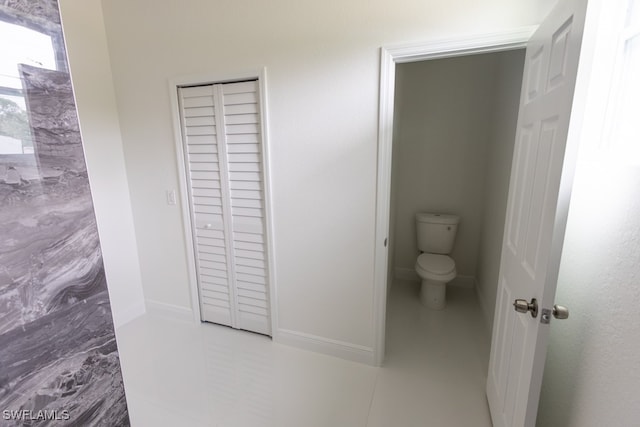 bathroom with toilet and tile patterned flooring