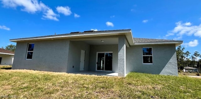 rear view of house featuring a lawn