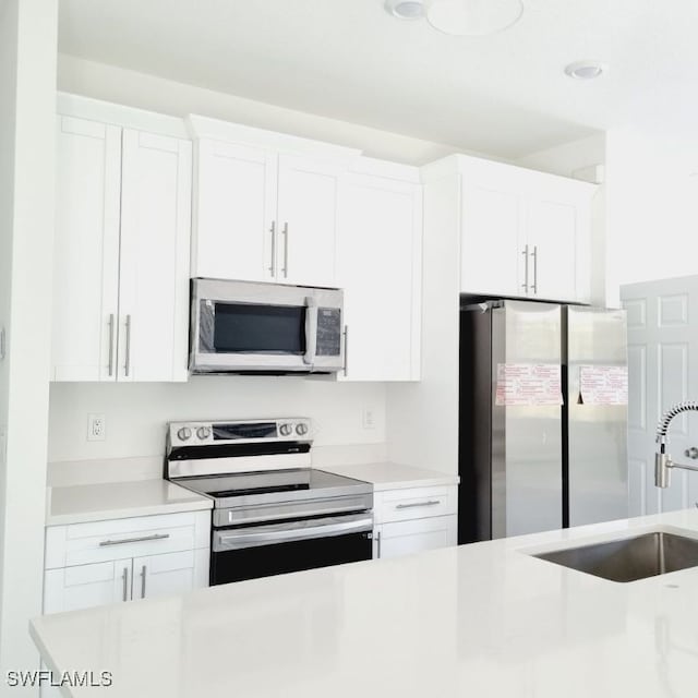 kitchen featuring white cabinetry, appliances with stainless steel finishes, and sink