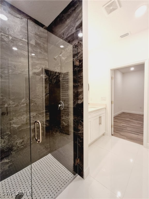 bathroom featuring vanity, walk in shower, and tile patterned flooring