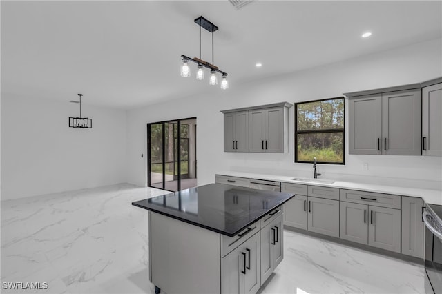 kitchen featuring pendant lighting, gray cabinets, a healthy amount of sunlight, and a kitchen island