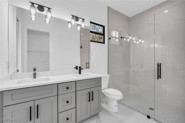 bathroom featuring a shower with door, vanity, and toilet