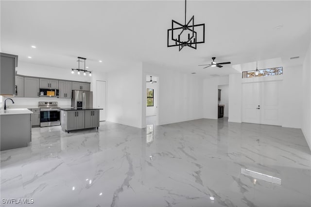 unfurnished living room featuring ceiling fan and sink