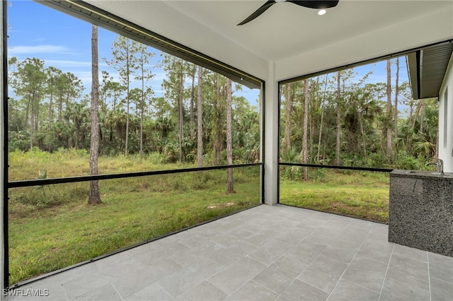 unfurnished sunroom with ceiling fan