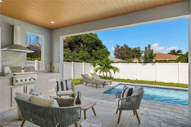 view of patio / terrace featuring area for grilling, a fenced in pool, and an outdoor kitchen