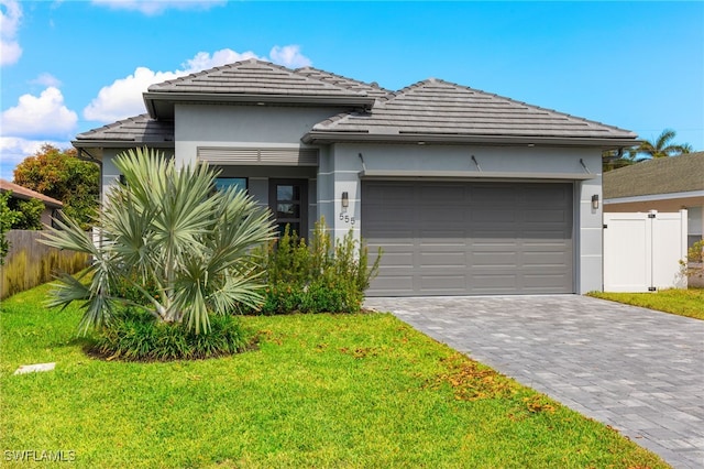 view of front of property featuring a garage and a front lawn