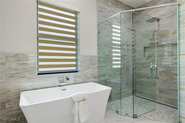 bathroom with tile walls and separate shower and tub