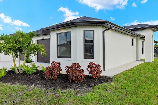 view of side of home with a garage and a lawn