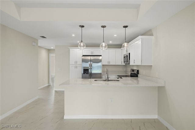 kitchen featuring appliances with stainless steel finishes, sink, kitchen peninsula, pendant lighting, and white cabinets