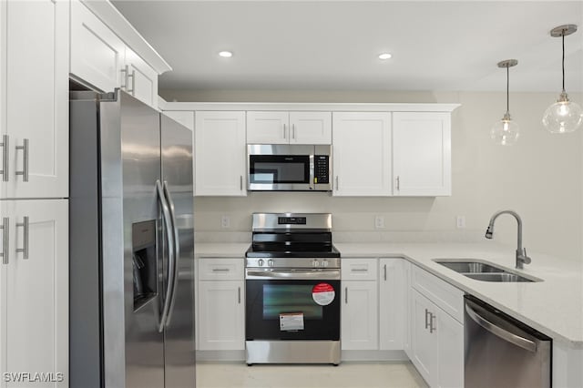 kitchen featuring white cabinetry, decorative light fixtures, and stainless steel appliances