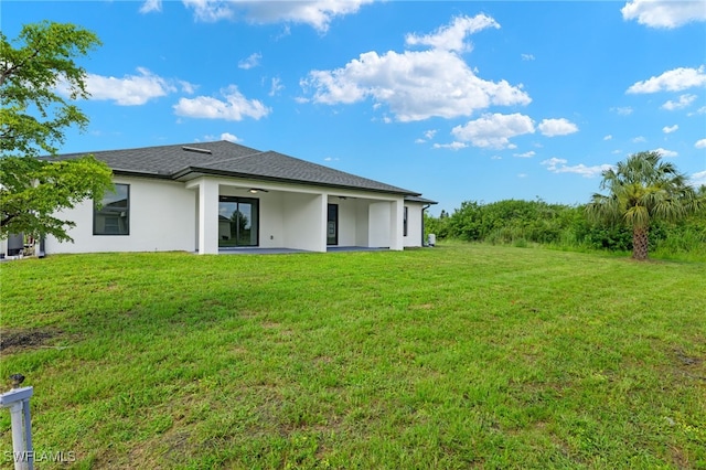 back of property featuring a patio area and a lawn