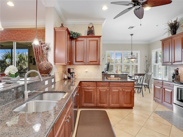 kitchen featuring pendant lighting, dark stone counters, crown molding, and sink