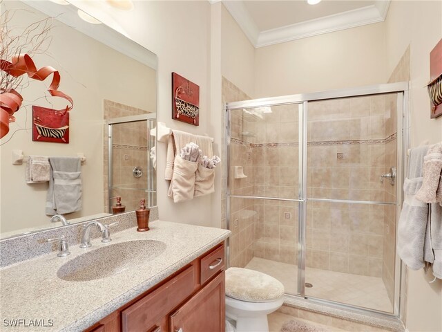 bathroom featuring an enclosed shower, ornamental molding, vanity, and toilet