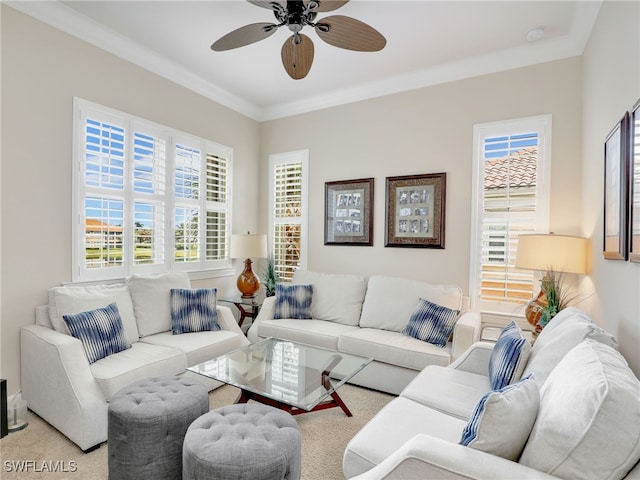 carpeted living room featuring ornamental molding and ceiling fan