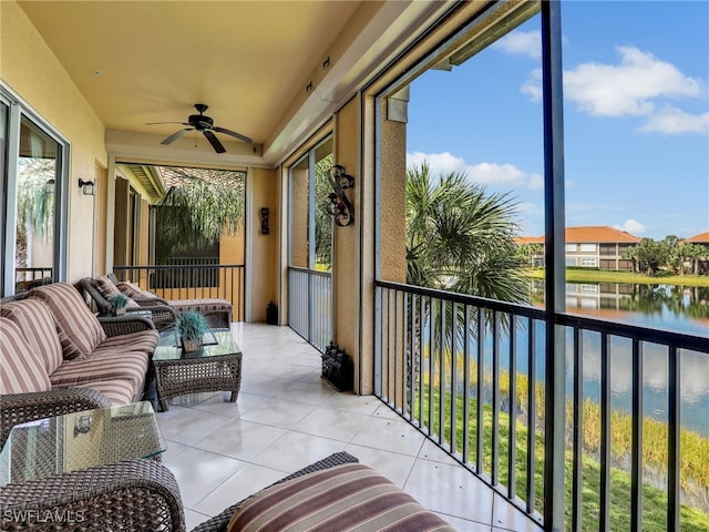 sunroom / solarium featuring ceiling fan, a water view, and plenty of natural light