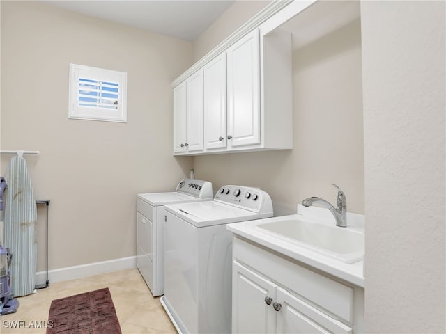 laundry area featuring independent washer and dryer, cabinets, sink, and light tile patterned floors