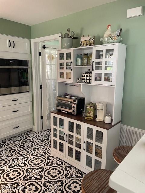 interior space with oven and white cabinetry