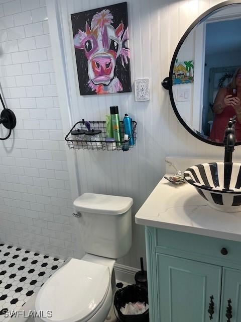 bathroom with vanity, toilet, and a tile shower