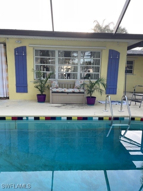 view of swimming pool featuring glass enclosure