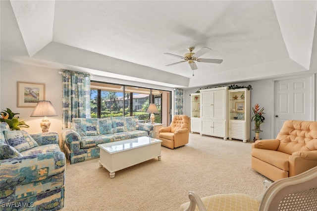 living room with carpet, ceiling fan, and a raised ceiling