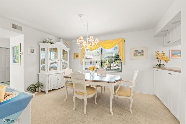 dining room with light colored carpet and an inviting chandelier