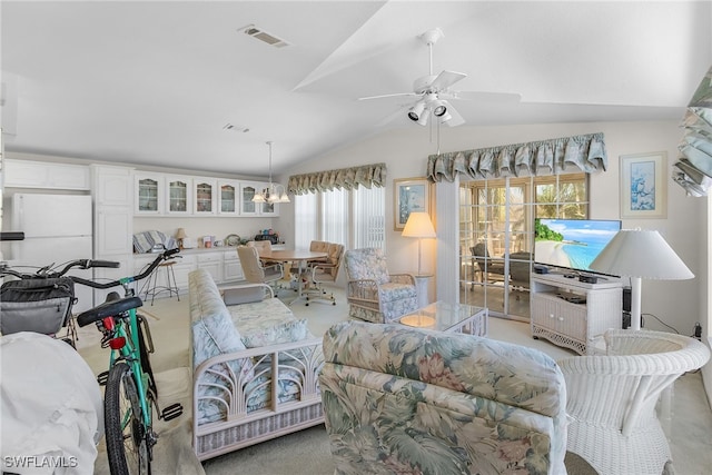 living room featuring light carpet, a healthy amount of sunlight, ceiling fan with notable chandelier, and vaulted ceiling