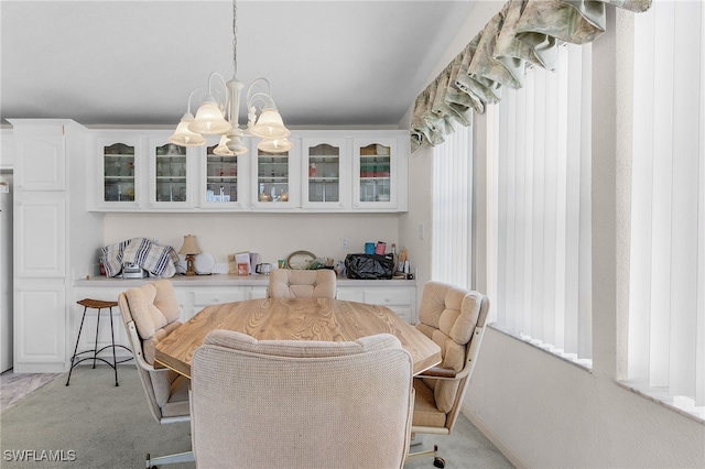 carpeted dining area with a chandelier