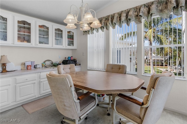 carpeted dining room with a notable chandelier and a wealth of natural light