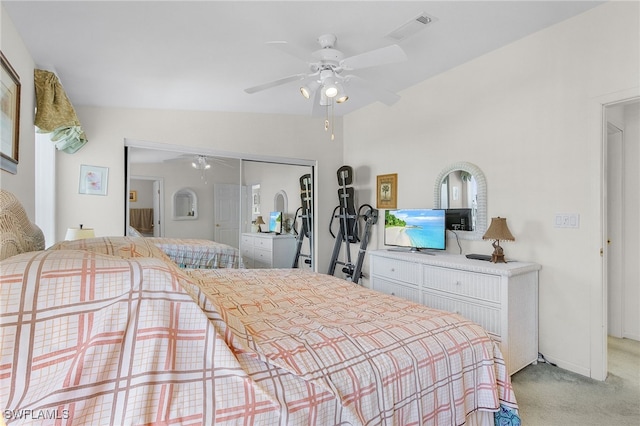 bedroom featuring a closet, ceiling fan, vaulted ceiling, and light colored carpet