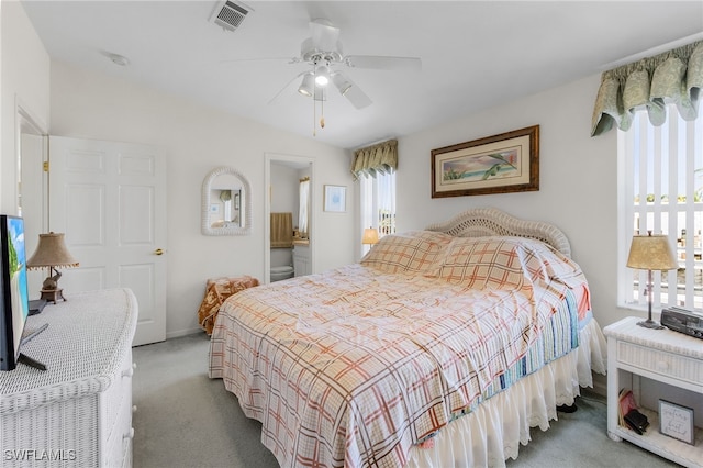 carpeted bedroom with multiple windows, ensuite bath, and ceiling fan