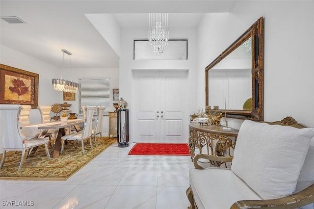 entryway with tile patterned floors, visible vents, and a chandelier