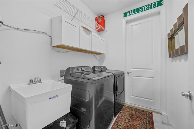 clothes washing area featuring cabinets, sink, and washing machine and clothes dryer