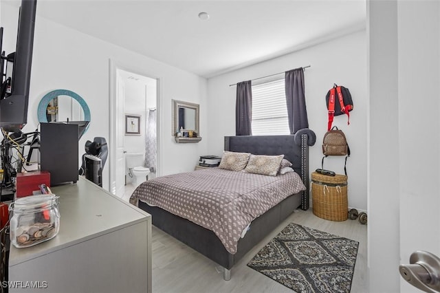 bedroom featuring ensuite bathroom and light hardwood / wood-style floors