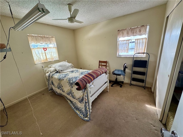 bedroom with ceiling fan, light carpet, and a textured ceiling