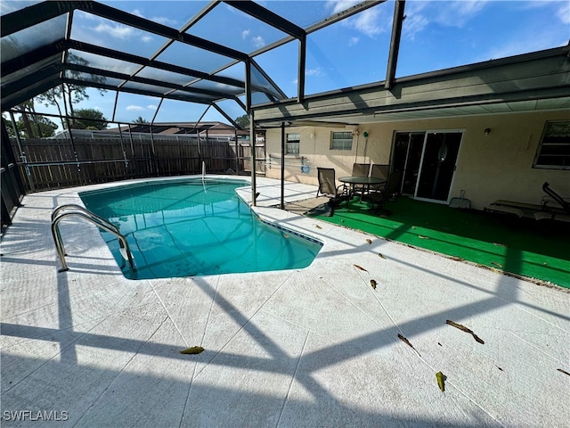 view of pool with a patio area and glass enclosure