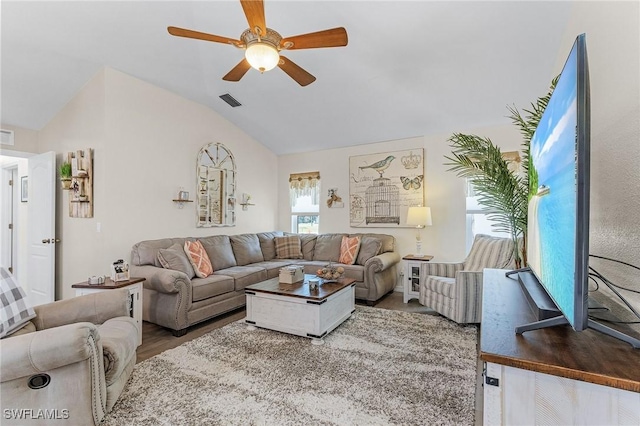 living room with hardwood / wood-style floors, ceiling fan, and vaulted ceiling