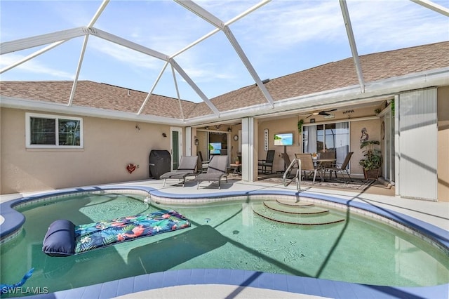 view of swimming pool with a lanai, ceiling fan, and a patio