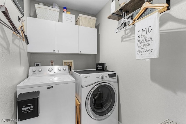 laundry area with washer and clothes dryer and cabinets