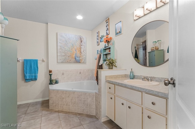 bathroom with tile patterned floors, vanity, and tiled bath