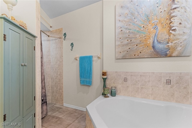 bathroom with a tub to relax in and tile patterned floors