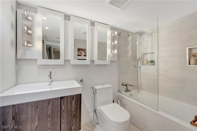 full bathroom featuring vanity, tiled shower / bath combo, and toilet