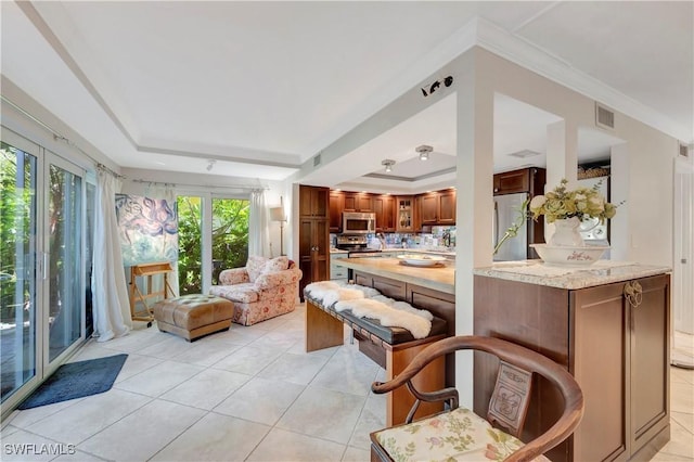 tiled living room featuring crown molding and a tray ceiling