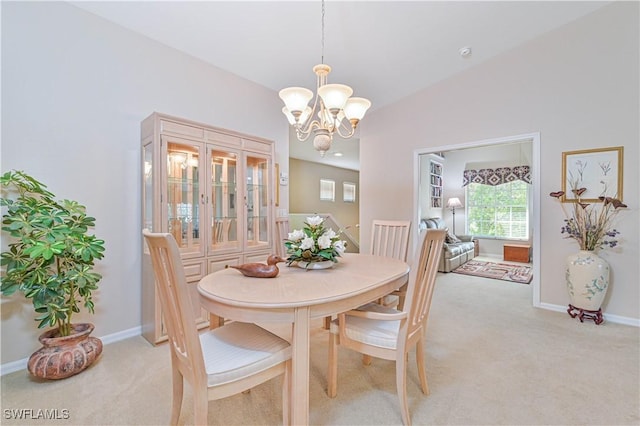 dining room featuring light colored carpet, vaulted ceiling, and a notable chandelier