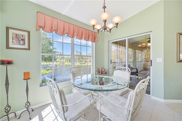 tiled dining space featuring a water view and a chandelier