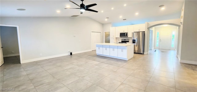 kitchen with lofted ceiling, white cabinets, ceiling fan, a kitchen island, and stainless steel appliances