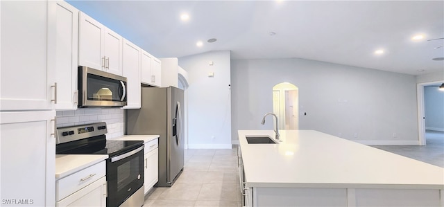 kitchen featuring a center island with sink, sink, vaulted ceiling, white cabinetry, and stainless steel appliances