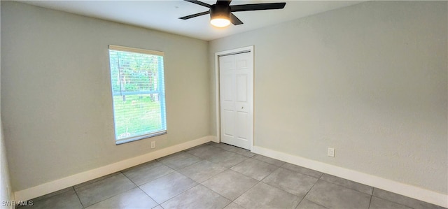 tiled spare room with ceiling fan