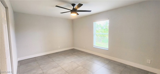 tiled spare room with ceiling fan