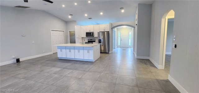 kitchen featuring appliances with stainless steel finishes, ceiling fan, high vaulted ceiling, white cabinetry, and an island with sink